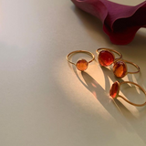 花の横に飾られた4つのオレンジガーネットの指輪